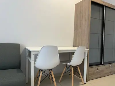 a desk with two white chairs and a table and a couch at Reno Hotel Ipoh in Ipoh