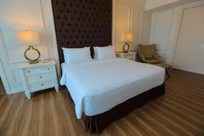 a hotel room with a large bed and a chair at Hotel Casuarina@Kuala Kangsar in Kuala Kangsar