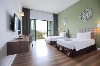 a hotel room with two beds and a television at Hotel Casuarina@Kuala Kangsar in Kuala Kangsar