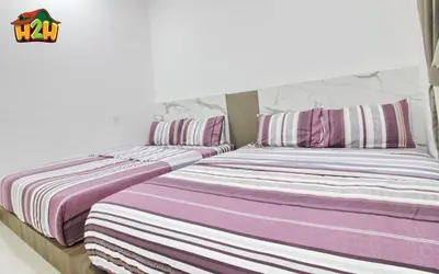two beds sitting next to each other in a bedroom at H2H - Botanical Majestic Ipoh in Ipoh