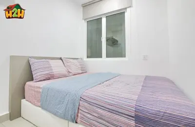 a bed in a white room with a window at H2H - Botanical Majestic Ipoh in Ipoh