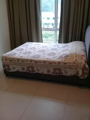 a bed sitting in a room with a window at 3 Rooms Apt @ Crown Imperial Court in Cameron Highlands