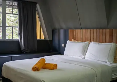 a bedroom with a bed with two yellow towels on it at Kavy Boutique Hotel @ KBH in Brinchang