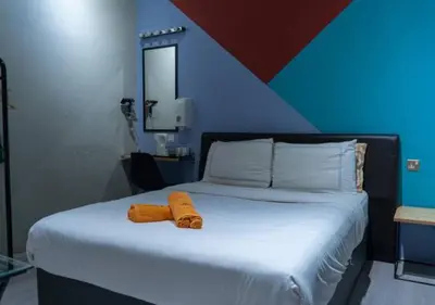 a bed with an orange towel on top of it at Kavy Boutique Hotel @ KBH in Brinchang