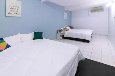 a bedroom with two beds and a blue wall at 4B12B 20 pax Corner House in Ipoh