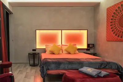 a bedroom with a bed with orange sheets and yellow pillows at Attic Hotel in George Town