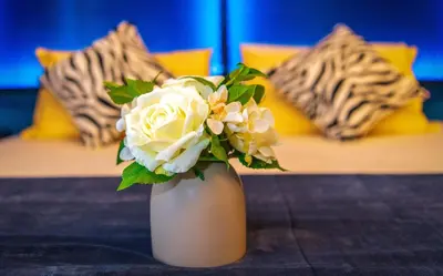 a white vase with flowers in it on a table at Attic Hotel in George Town