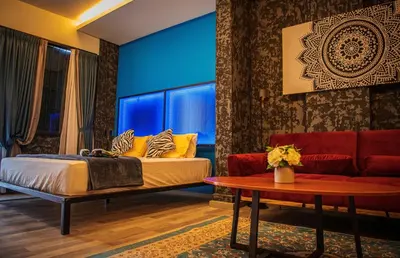 a bedroom with a bed and a couch and a table at Attic Hotel in George Town