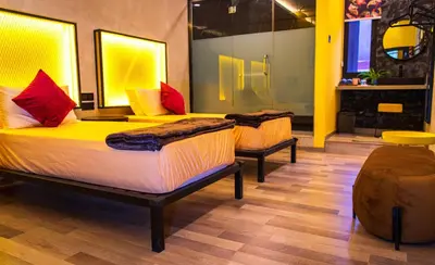 two beds in a room with yellow and red pillows at Attic Hotel in George Town