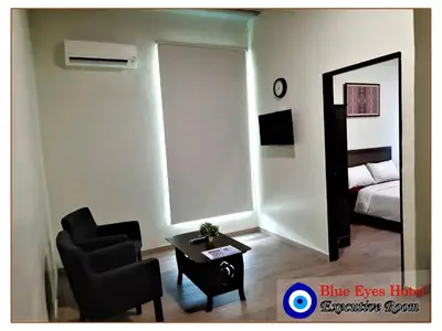 a living room with a chair and a mirror at Blue Eyes Hotel in Kepala Batas
