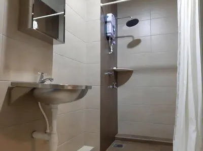 a bathroom with a sink and a shower at Blue Eyes Hotel in Kepala Batas