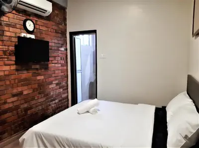 a bedroom with a white bed and a brick wall at Blue Eyes Hotel in Kepala Batas