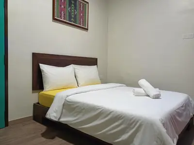 a bedroom with two beds with white sheets at Blue Eyes Hotel in Kepala Batas