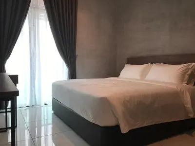 a bed with white sheets and pillows in a bedroom at Dandelion Inn in Simpang Pulai