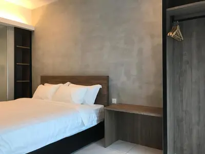 a bedroom with a bed with white sheets at Dandelion Inn in Simpang Pulai