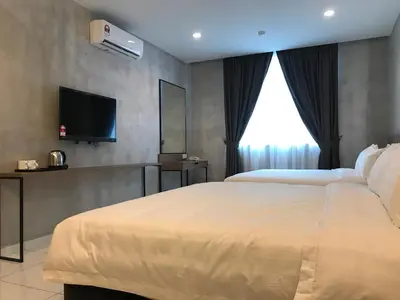 a hotel room with a bed and a flat screen tv at Dandelion Inn in Simpang Pulai