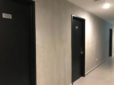 a black door in a room with a wall at Dandelion Inn in Simpang Pulai