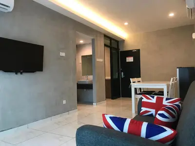 a living room with a couch and a flat screen tv at Dandelion Inn in Simpang Pulai