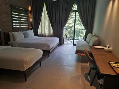 a hotel room with two beds and a desk and a table at Sementra Hot Spring Nature Resort in Gopeng