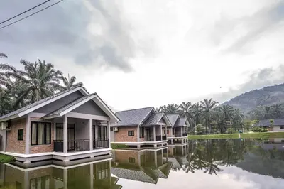 a row of houses on a body of water at Sementra Hot Spring Nature Resort in Gopeng