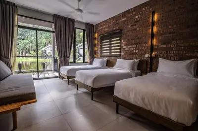 a bedroom with two beds and a brick wall at Sementra Hot Spring Nature Resort in Gopeng