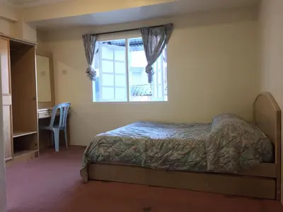 a bedroom with a bed and a window and a desk at Homstay Desa Anthurium in Tanah Rata