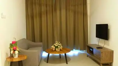 a living room with a couch and a tv at Barrington Square 2 Rooms Apartment at Golden Hill Night Market in Brinchang