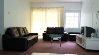 a living room with a couch and a tv at MERLIN HOME DESA ANTHURIUM in Tanah Rata