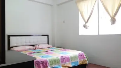 a bedroom with a bed with a colorful comforter at MERLIN HOME DESA ANTHURIUM in Tanah Rata