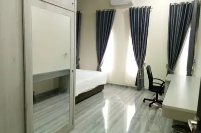 a mirror in a room with a bed and a chair at Serantau Mayang by the Bliss in Bagan Serai