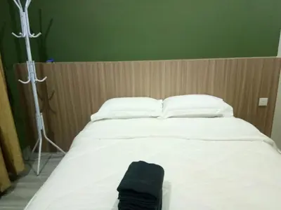 a white bed with a black towel on it at Serantau Mayang by the Bliss in Bagan Serai