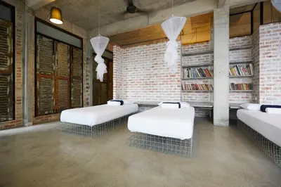 two beds in a room with a brick wall at Belakang KongHeng By DreamScape in Ipoh