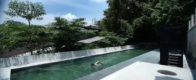 a person is swimming in a swimming pool at Belakang KongHeng By DreamScape in Ipoh