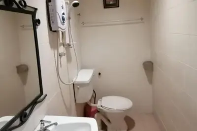 a bathroom with a toilet and a sink and a mirror at Hotel O Prai Jaya in Perai