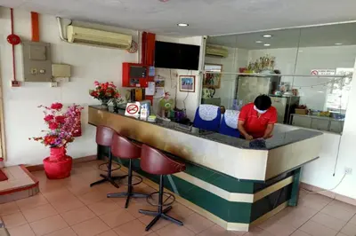a man sitting at a counter in a restaurant at Hotel O Prai Jaya in Perai
