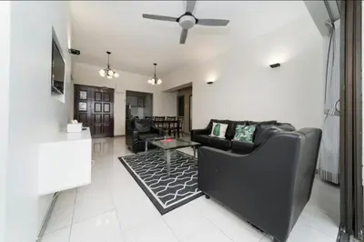 a living room with a black couch and a table at Deluxe VIP Seaview Batu Ferringhi 1503 - 3 Rooms in Batu Ferringhi
