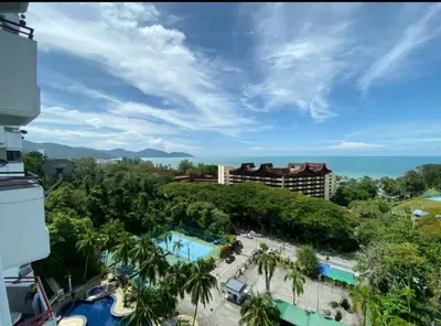 a view of a resort with a pool and the ocean at Deluxe VIP Seaview Batu Ferringhi 1503 - 3 Rooms in Batu Ferringhi