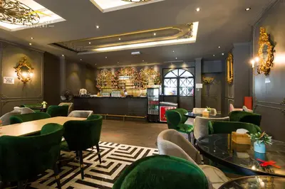 a restaurant with green chairs and tables and a bar at Zetter Suites by Dreamscape in Cameron Highlands