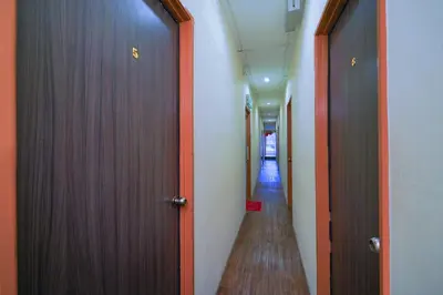 a hallway with two doors and a long corridor at Hotel O V Stay Guesthouse in Ayer Itam