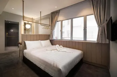 a bedroom with a large bed with a large window at Masson Hotel Butterworth in Perai