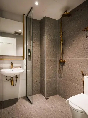 a bathroom with a shower and a toilet and a sink at Masson Hotel Butterworth in Perai