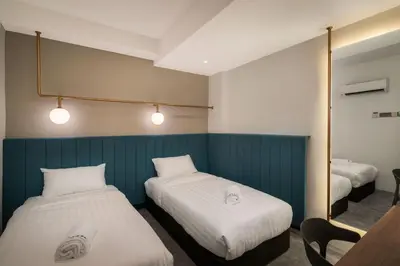 a hotel room with two beds and a mirror at Masson Hotel Butterworth in Perai