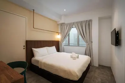 a hotel room with a bed and a window at Masson Hotel Butterworth in Perai