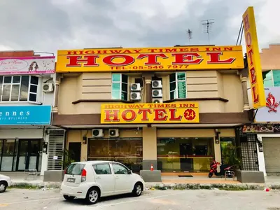 a white car parked in front of a hotel at Highway Times Inn Hotel in Ipoh