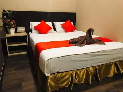 a bedroom with a large bed with red pillows at Highway Times Inn Hotel in Ipoh