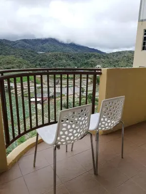 two chairs sitting on a balcony with a view at Green View Home Cameron Highlands in Brinchang