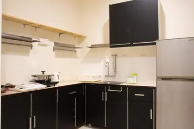 a kitchen with black cabinets and a stainless steel refrigerator at Profolio @ Mansion One in George Town