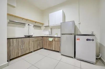 a kitchen with a refrigerator and wooden cabinets at Profolio @ Mansion One in George Town