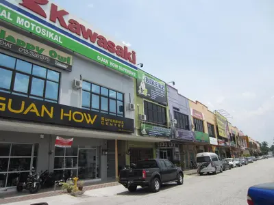 a row of buildings on a city street with a truck at Happy Owl in Ipoh