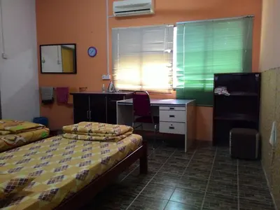 a bedroom with two beds and a desk at Happy Owl in Ipoh